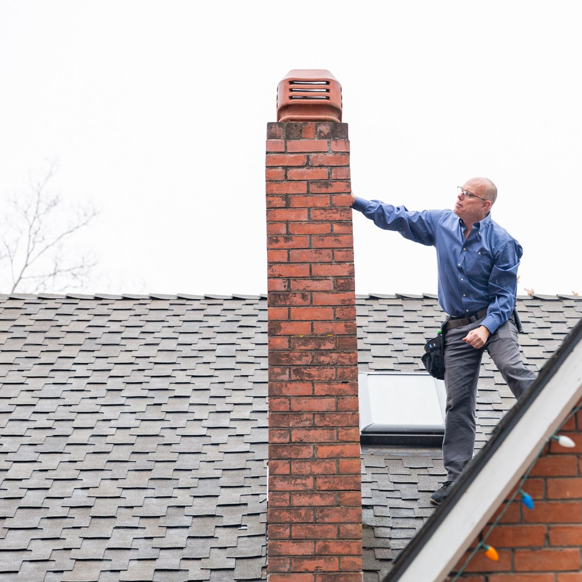 David inspecting a chimney on the roof